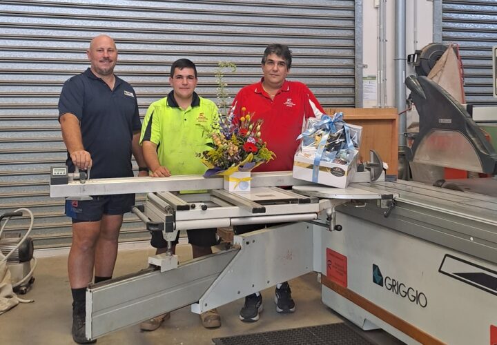 Men standing next to Griggio panel saw