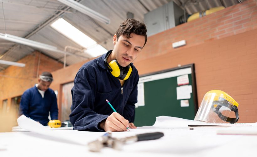 Latin American STEM student in an engineering class at a workshop and writing notes â education concepts